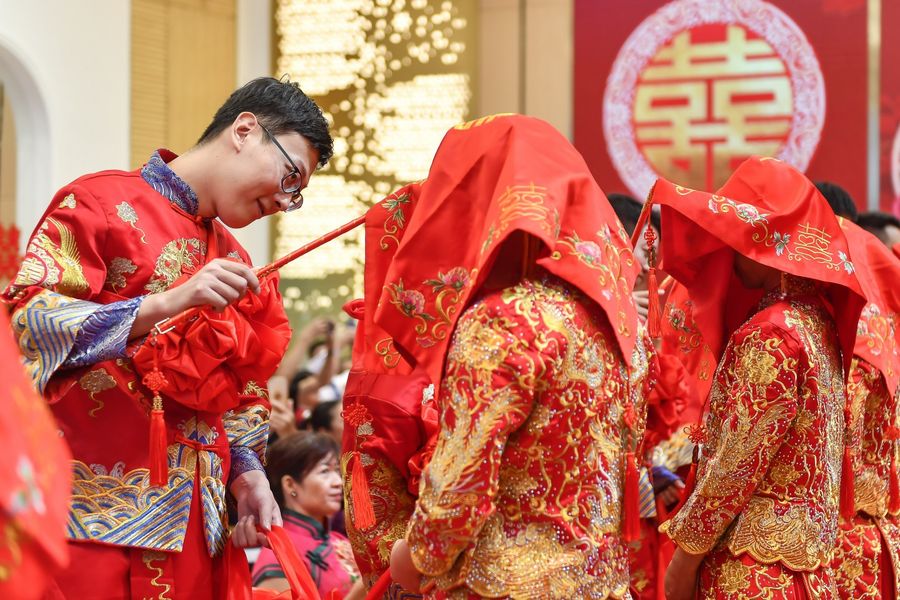 30 couples tie the knot on 11 November 2019 at Guangzhou, wearing traditional Chinese wedding gowns. The picture shows the groom unveiling his bride. (CNS)