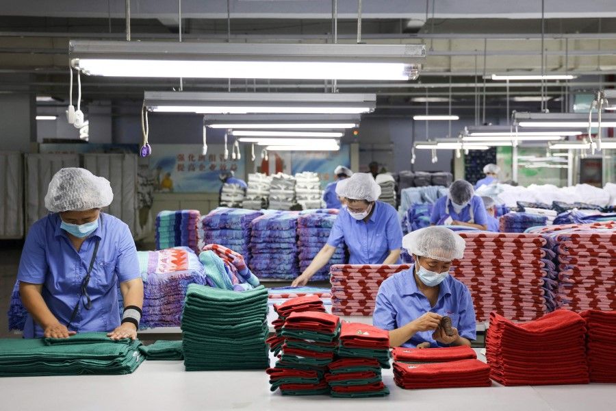 Workers produce towels for exportation at a factory in Binzhou, in China's eastern Shandong province, on 28 June 2023. (AFP)