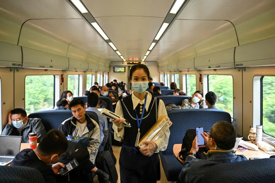 A train attendant walks in a train heading from Shanghai to Chengdu, in Zhenjiang, in China's eastern Jiangsu province on 10 May 2023. (Hector Retamal/AFP)
