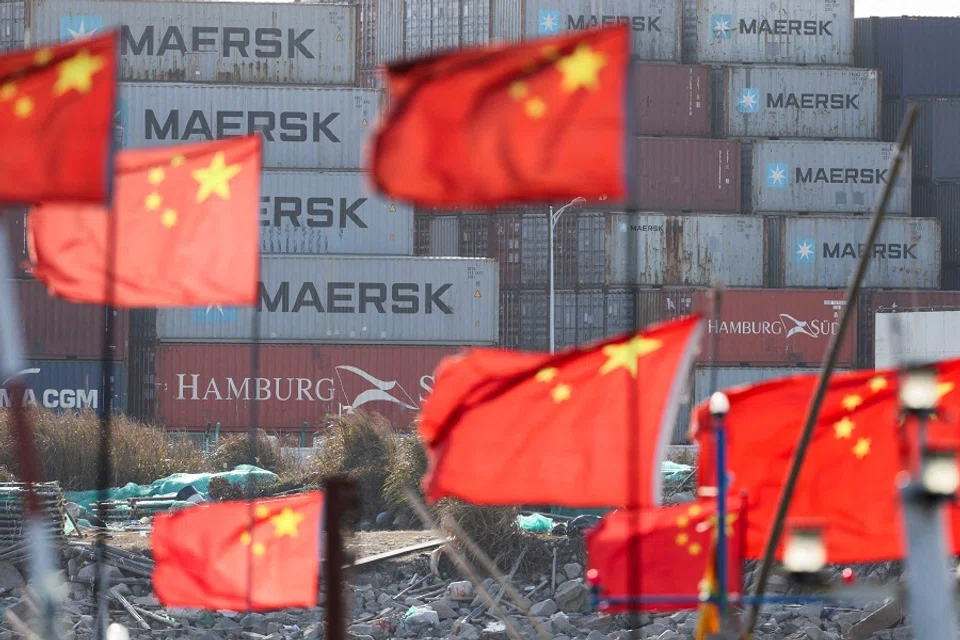 Chinese national flags flutter near shipping containers at the Yangshan Port outside Shanghai, China, on 7 February 2025. (Go Nakamura/Reuters)