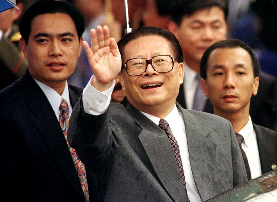 Chinese President Jiang Zemin smiles through the rain and waves to a crowd upon his arrival in Hong Kong, 30 June 1997. (Simon Kwong/File Photo/Reuters)