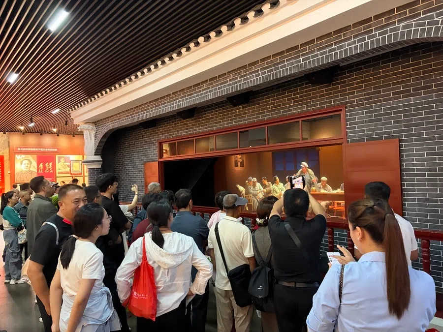 Visitors at an commemorative exhibition in Zunyi gather around a diorama on 22 September 2026.
