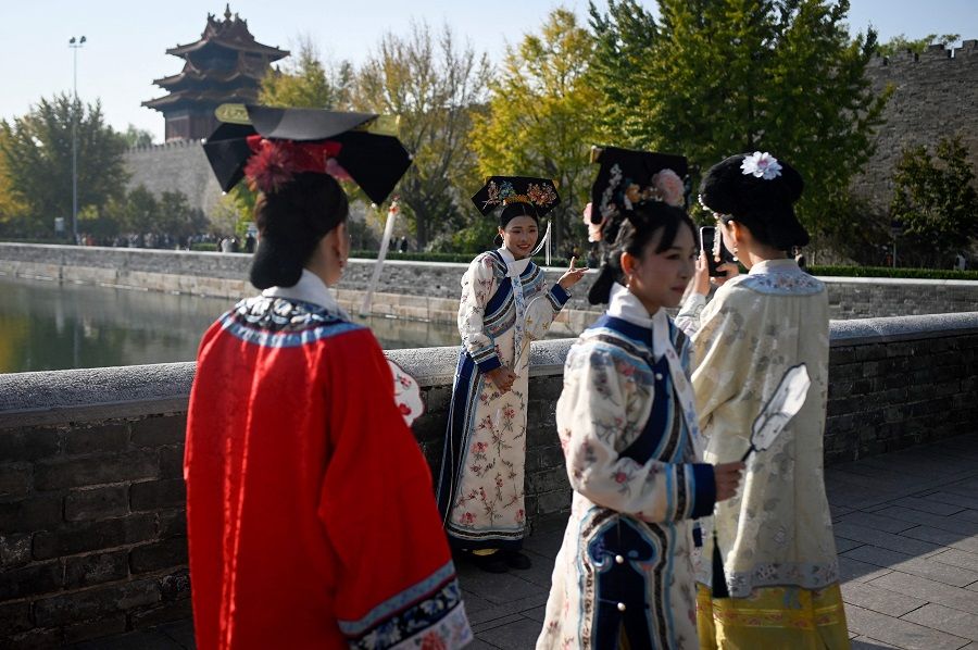 A group of women, dressed in Qing dynasty clothing, prepare to visit the Forbidden City in Beijing on 8 November 2023. (Wang Zhao/AFP)