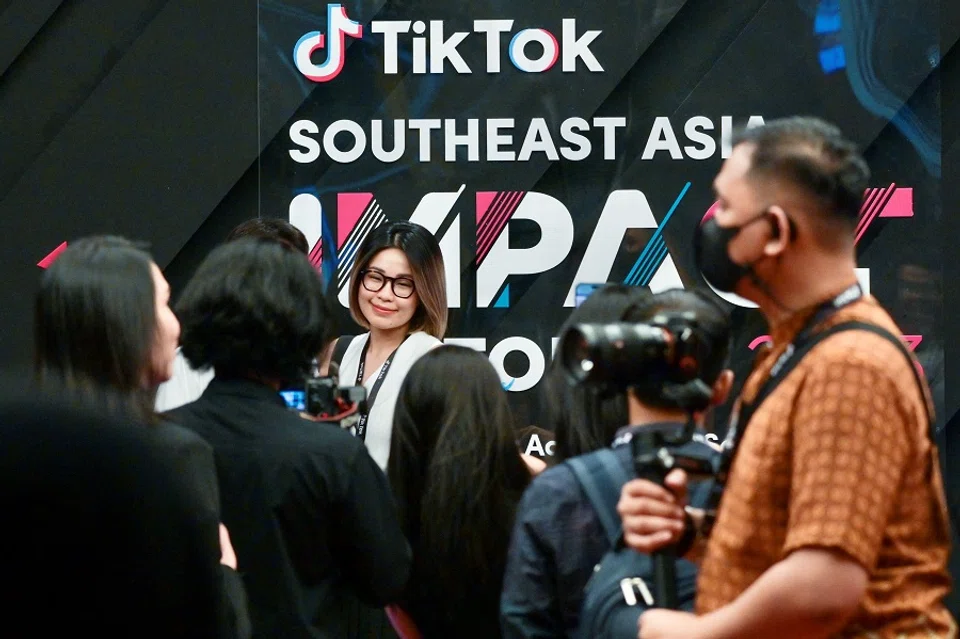 A woman poses in front of signage before the TikTok Southeast Asia Impact Forum 2023 in Jakarta, Indonesia, on 15 June 2023. (Bay Ismoyo/AFP)