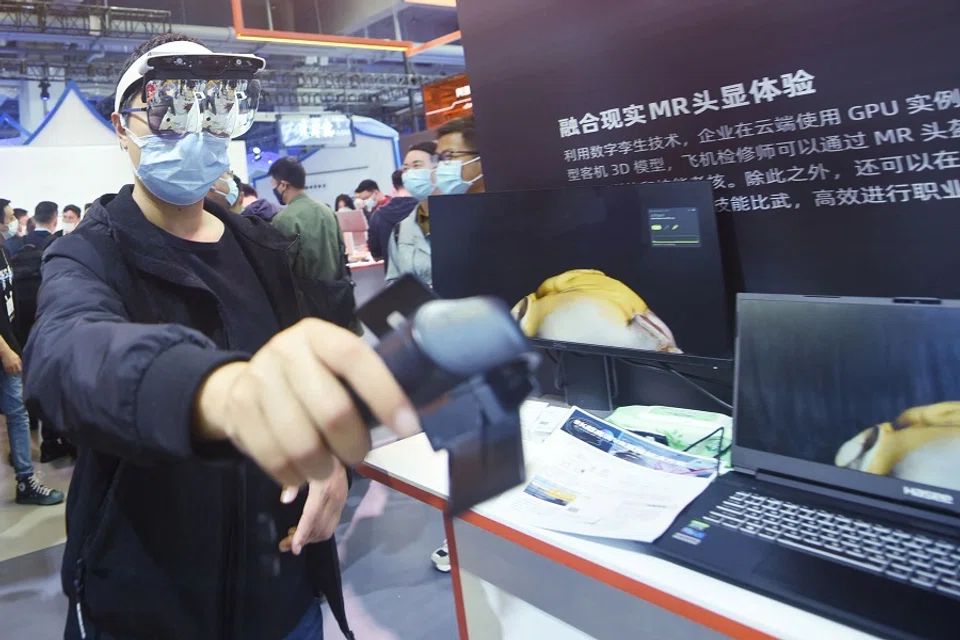 A visitor tries mixed reality glasses at the Apsara Conference, a cloud computing and artificial intelligence (AI) conference, in Hangzhou, Zhejiang province, China, on 19 October 2021. (STR/AFP)