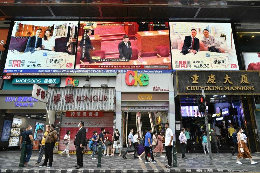 China's President Xi Jinping (top C) is shown on a large video screen in Hong Kong on May 28, 2020, during a live broadcast of the National People's Congress (NPC) in Beijing. (Anthony Wallace/AFP)