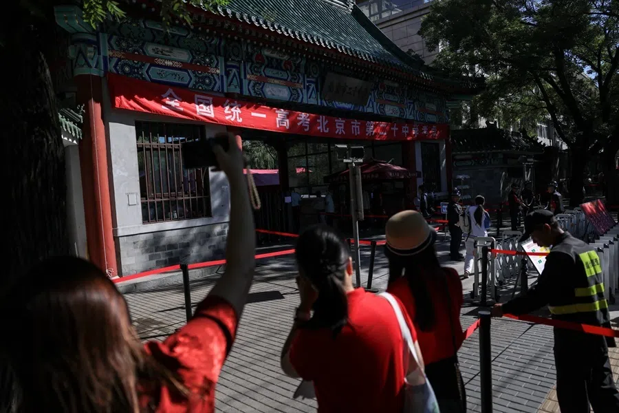 ​Teachers cheer for their students outside a national college entrance exam venue in Beijing, China, on 7 June 2026. The plight of their colleagues at Chinese universities has drawn recent attention, as one university announces tougher reviews.