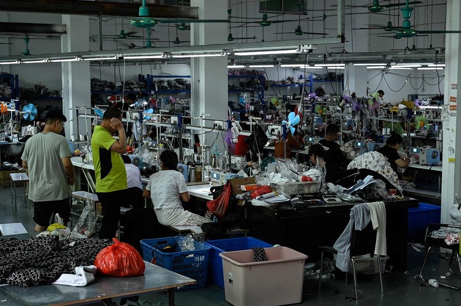Workers make clothes at a garment factory that supplies Shein, a cross-border fast fashion e-commerce company in Guangzhou, Guangdong province, China, on 18 July 2022. (Jade Gao/AFP)
