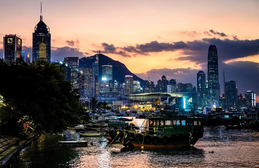 The sun sets behind Hong Kong’s skyline on 1 November 2024. (Mladen Antonov/AFP)
