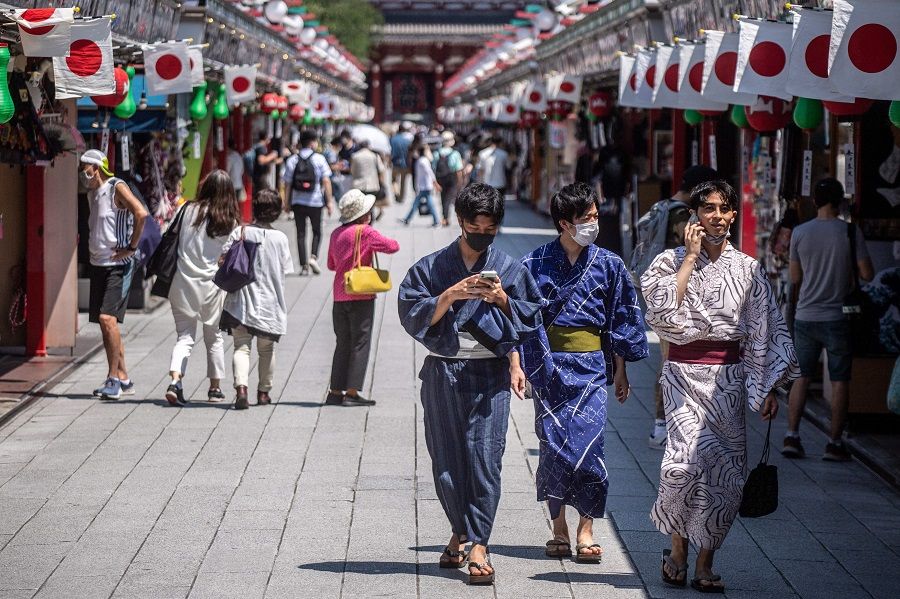 People in traditional outfits walk in Sensoji temple in Tokyo, Japan on 22 July 2021. (Philip Fong/AFP)