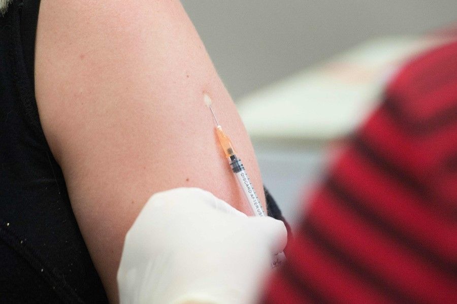 In this file photo a volunteer is injected with a syringe containing either the vaccine or a placebo, at the start of a clinical trial being set up by TASK, a clinical research organisation based in Cape Town. (Rodger Bosch/AFP)