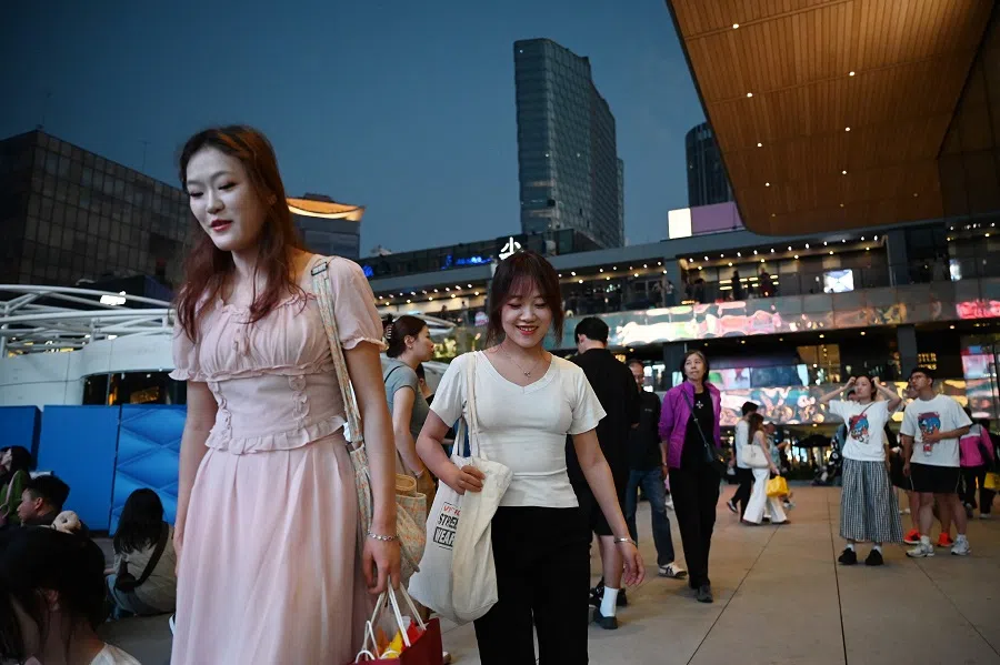 People walk in a shopping mall in Beijing, China, on 16 September 2024. (Greg Baker/AFP)