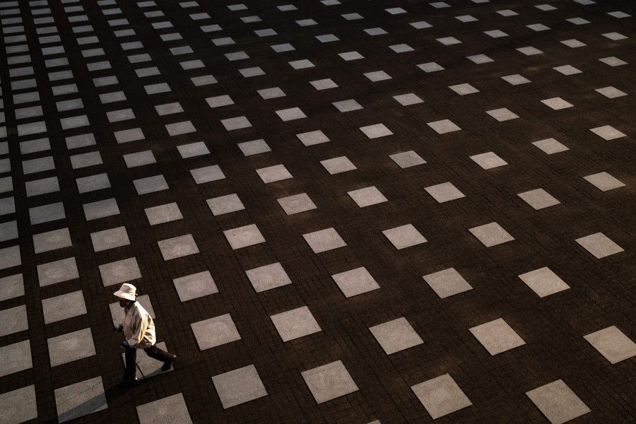A woman wearing a face mask walks at a square of a park in Yokohama, 10 May 2020. (Philip Fong/AFP)