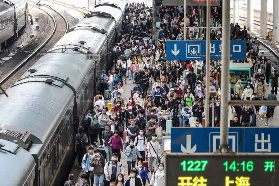 Passengers prepare to board their train at the Nanjing Train Station, in China's eastern Jiangsu province, on 28 April 2023. (AFP)