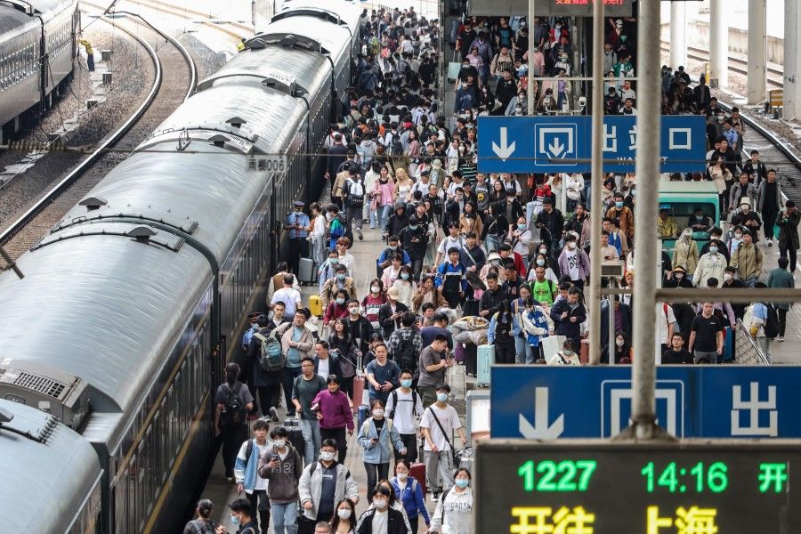 Passengers prepare to board their train at the Nanjing Train Station, in China's eastern Jiangsu province, on 28 April 2023. (AFP)