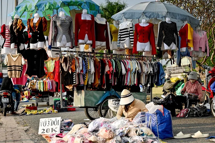 This photo taken on 23 December 2024 shows vendors waiting for customers at a street market, in Ho Chi Minh City, Vietnam. (Nhac Nguyen/AFP)