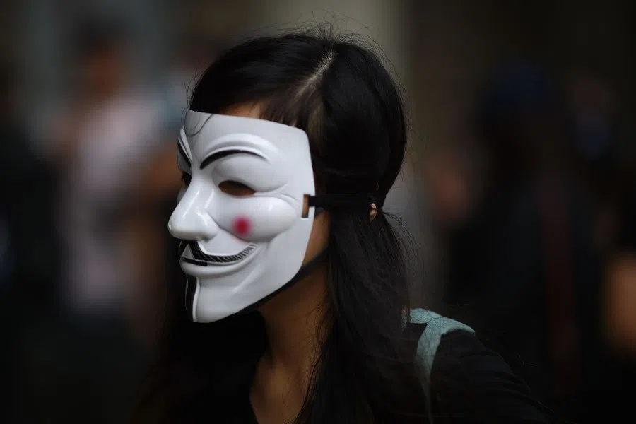 A protester, wearing a stylised Guy Fawkes mask popularised by the V For Vendetta comic and film, stands outside the High Court premises in support of activist Edward Leung, sentenced to six years jail for taking part in the 2016 Mongkok riots, during an appeal hearing in Hong Kong, October 2019. (Mohd Rasfan/AFP)