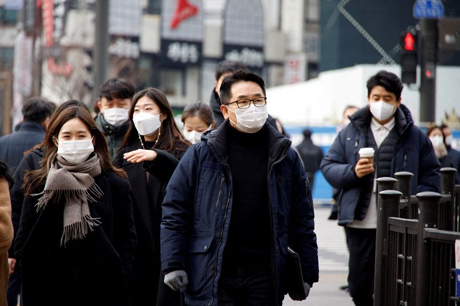 People wearing masks walk on a street in downtown Seoul, South Korea, 5 January 2022. (Heo Ran/File Photo/Reuters)