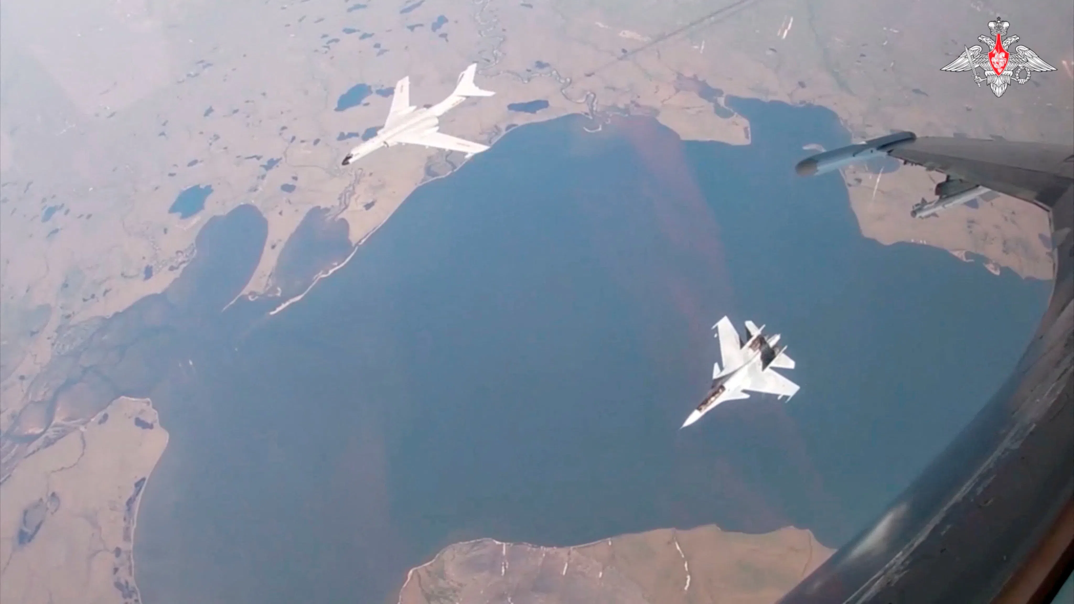 A H-6K bomber of the Chinese People’s Liberation Army (PLA) Air Force is accompanied by a Russian Sukhoi Su-30CM jet fighter during joint Russian and Chinese military plane patrols near the US state of Alaska, in this still image from video released 25 July 2024. (Russian Defence Ministry/Handout via Reuters)