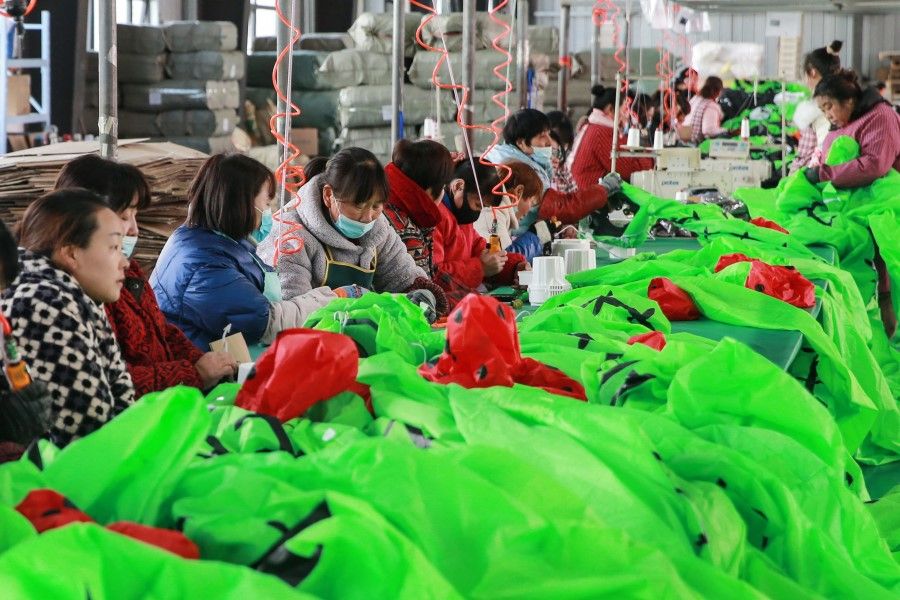Workers produce inflatable toys for export at a factory in Huaibei, in China's eastern Anhui province on 15 February 2023. (AFP)