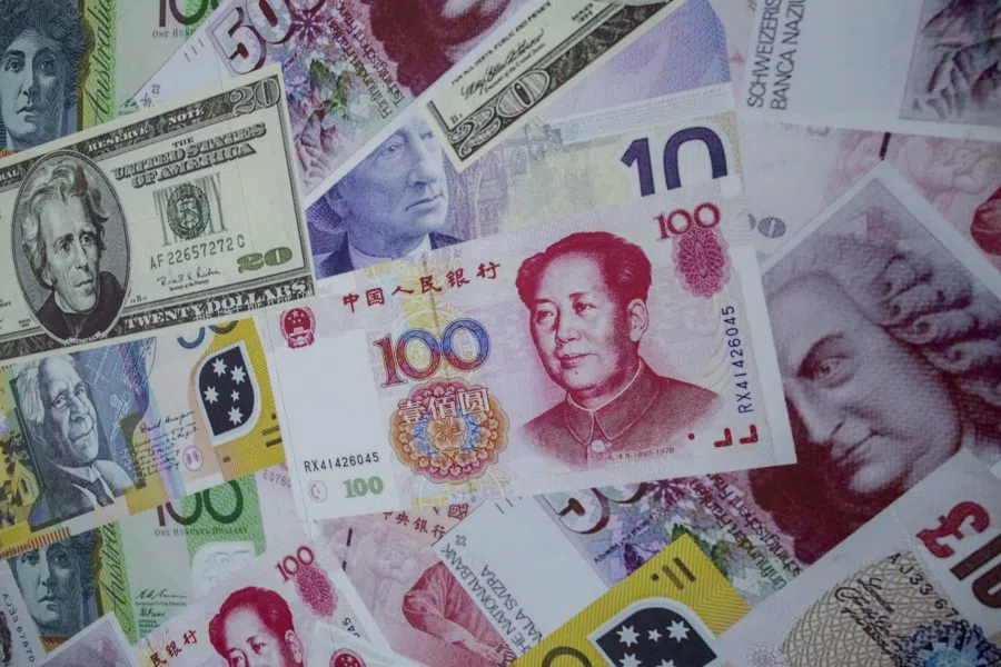 An advertisement poster promoting China's renminbi (RMB) or yuan , U.S. dollar and Euro exchange services is seen outside at foreign exchange store in Hong Kong, China, 13 August 2015. (Tyrone Siu/Reuters)