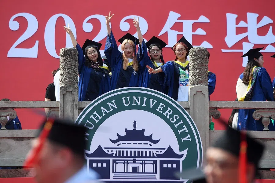 Graduates of Wuhan University pose for photos during the graduation ceremony in Wuhan, in China's central Hubei province on 20 June 2023. (AFP)