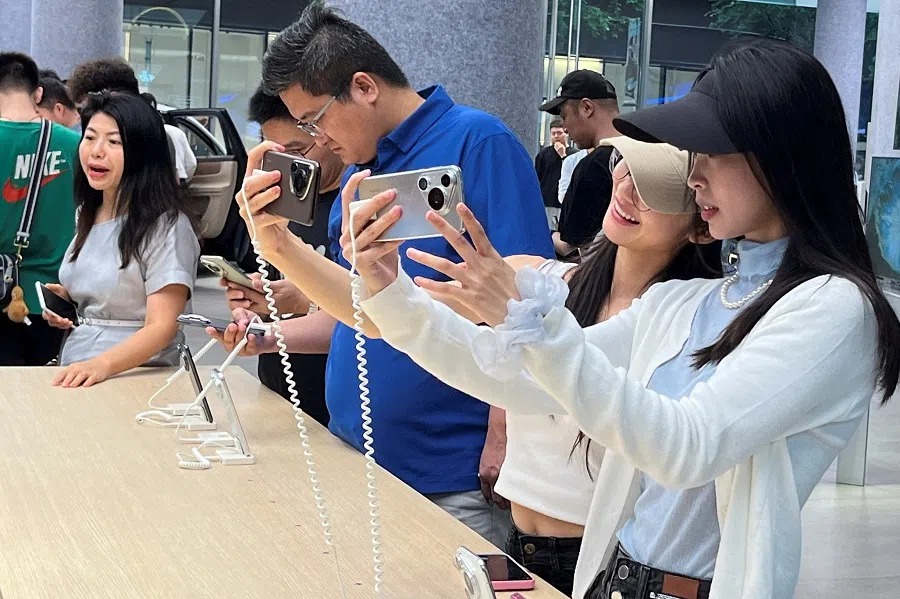 Customers look at new Huawei Pura 70 series smartphones, as the series models go on sale at a Huawei’s flagship store in Shenzhen, China, on 18 April 2024. (David Kirton/Reuters)