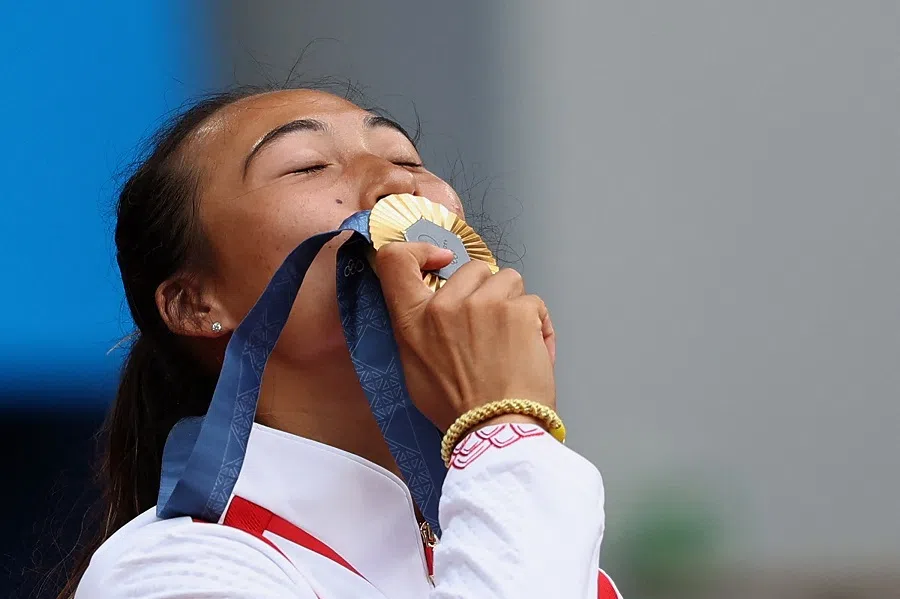 Gold medallist Zheng Qinwen of China kisses her medal at the tennis women’s singles victory ceremony, Roland-Garros Stadium, Paris, France, on 3 August 2024. (Violeta Santos Moura/Reuters)
