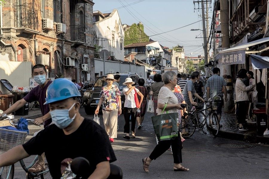Residents walk past street stalls in an older neighbourhood in Shanghai, China on 30 August 2021. (Qilai Shen/Bloomberg)