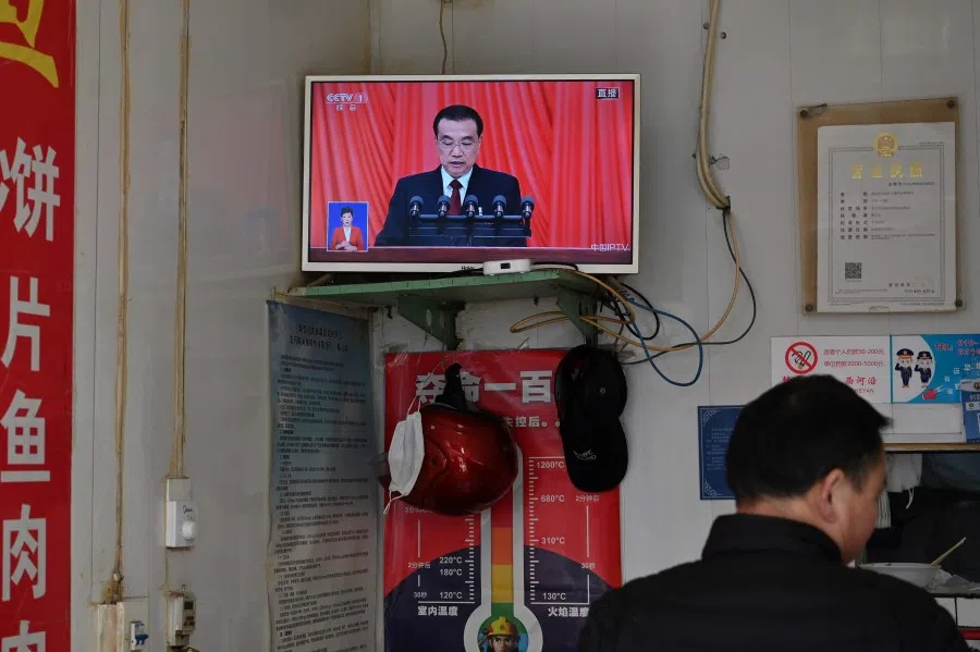 A TV screen in a restaurant shows live coverage of Chinese Premier Li Keqiang reading his work report during the opening session of the National People's Congress in Beijing on 5 March 2023. (Greg Baker/AFP)