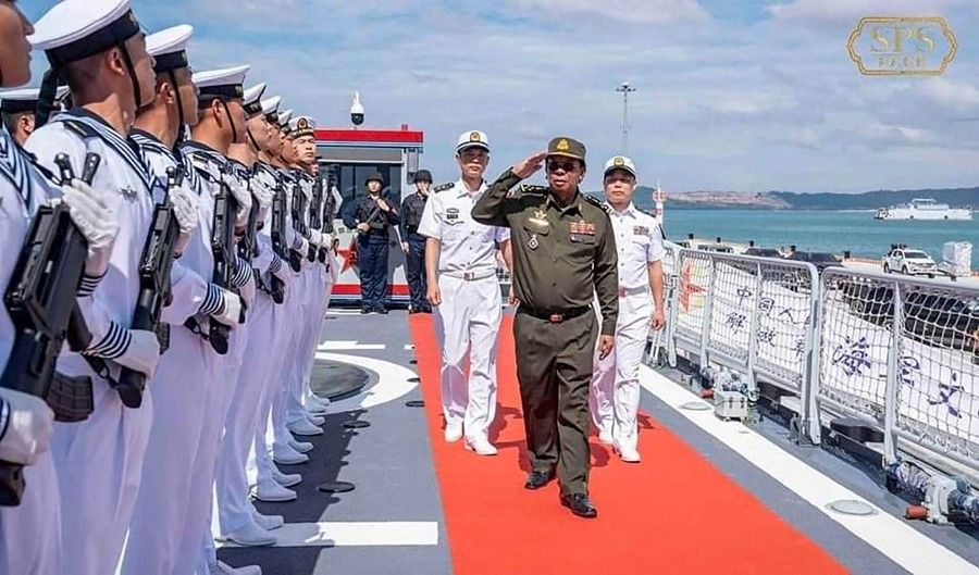 This handout photo taken on 3 December 2023 and obtained on 7 December 2023 from Cambodia's Defence Minister Tea Seiha's Facebook page shows Cambodia's former Defence Minister Tea Banh (centre) saluting Chinese Navy soldiers during his visit to two Chinese warships docked at the Ream Naval Base near Cambodia's port city of Sihanoukville. (Handout/Cambodia's Defence Minister Tea Seiha's Facebook page/AFP)