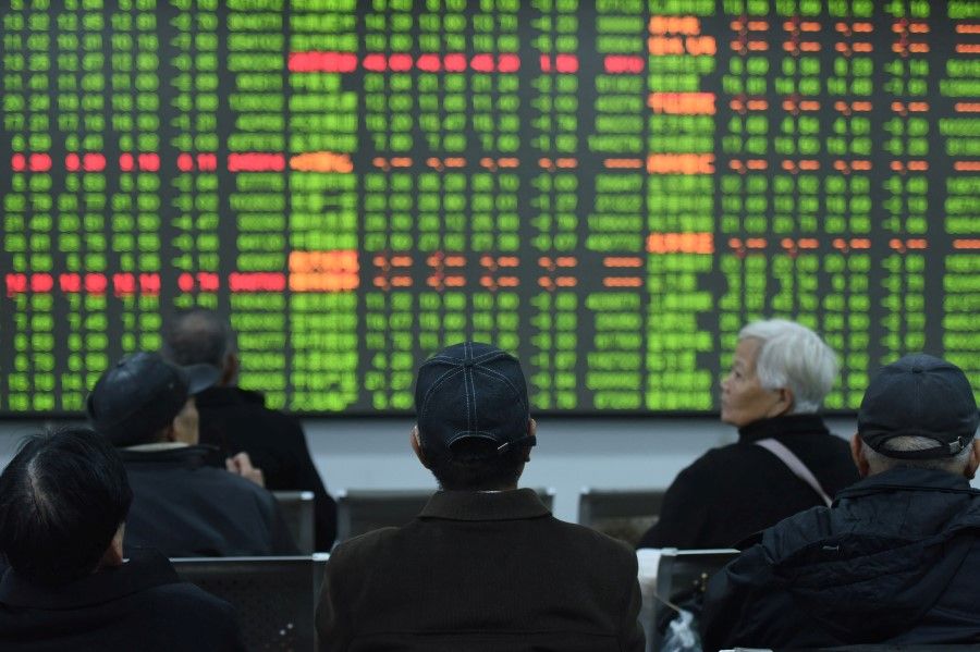 Investors sit in front of a board showing stock information at a brokerage house in Hangzhou, Zhejiang province, February 3, 2020. (China Daily via REUTERS)