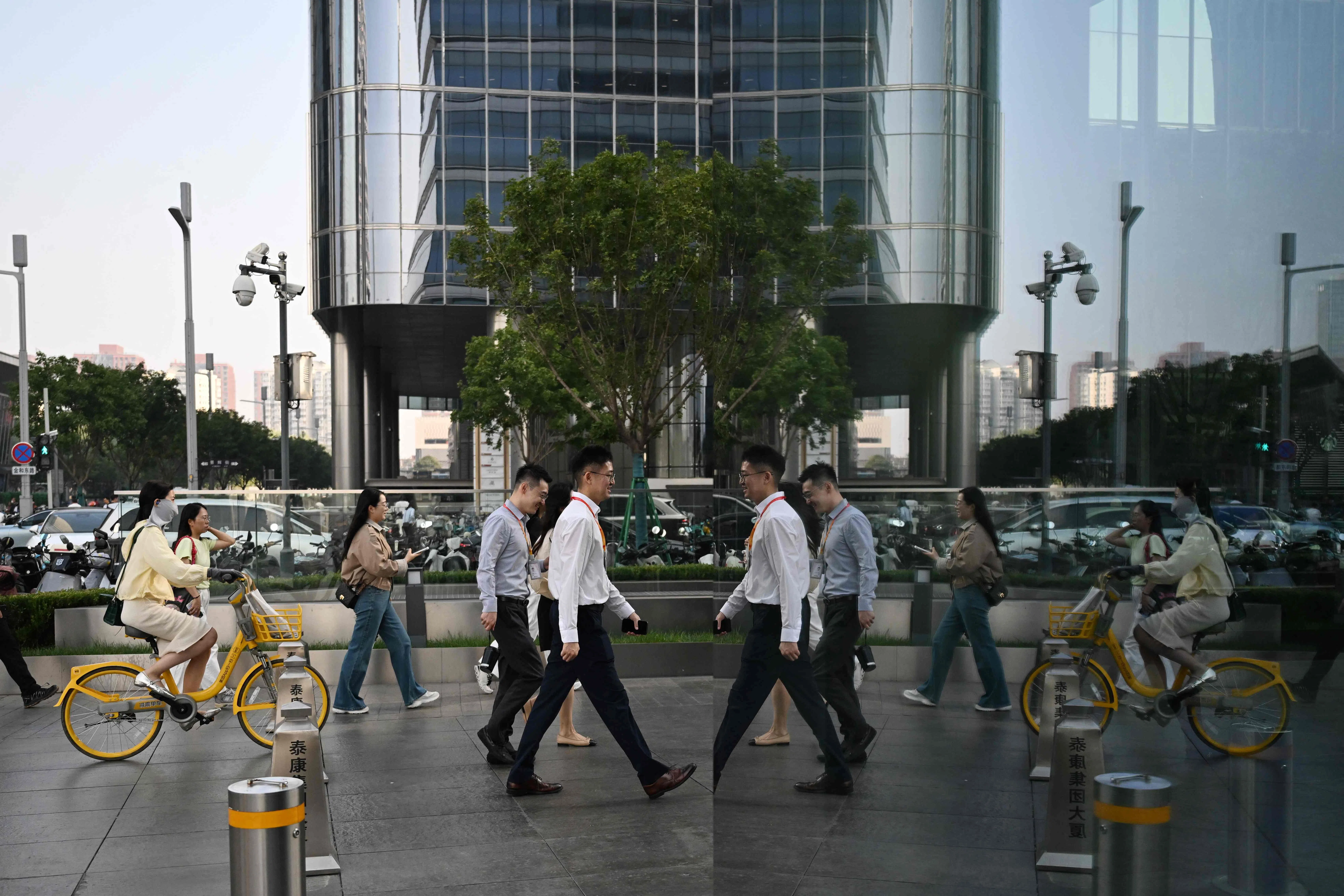 Office workers walk to their buildings in the central business district in Beijing on 23 September 2026.