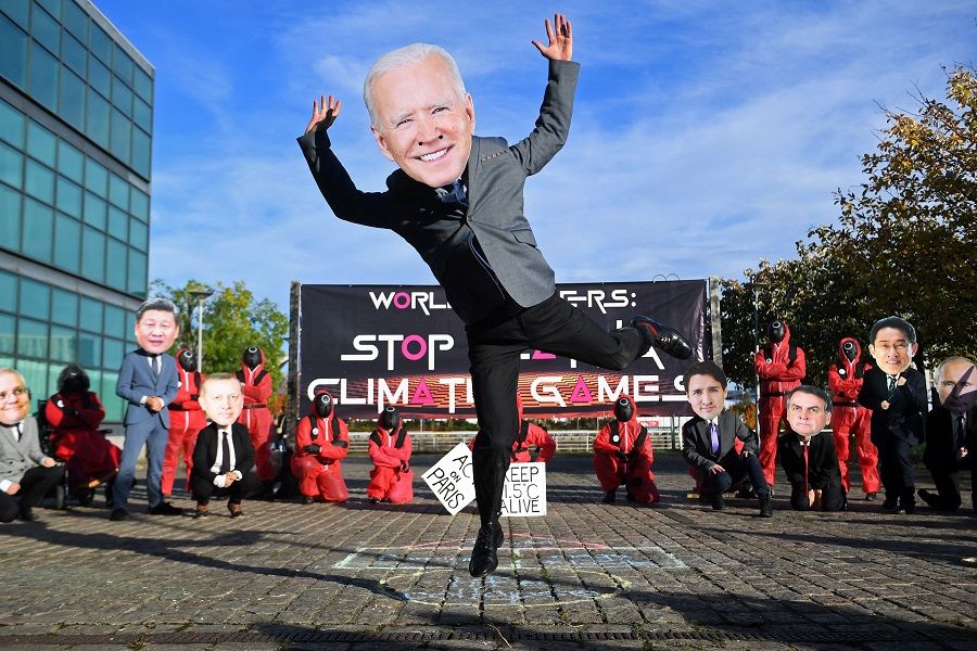 Climate change activists wearing masks depicting images of world leaders, including US President Joe Biden, take part in a "Squid Game" themed demonstration near the Scottish Event Campus (SEC), the venue of the COP26 UN Climate Change Conference in Glasgow, Scotland, on 2 November 2021. (Andy Buchanan/AFP)