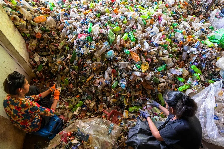 Workers sort plastic bottles at a plastic recycling facility in Panagoda, Sri Lanka, on 10 June 2023. (Ishara S. Kodikara/AFP)