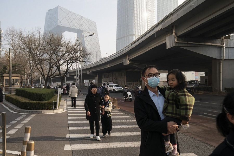 Pedestrians cross a road in front of the CCTV headquarters building in Beijing, China, on 6 March 2023. (Qilai Shen/Bloomberg)