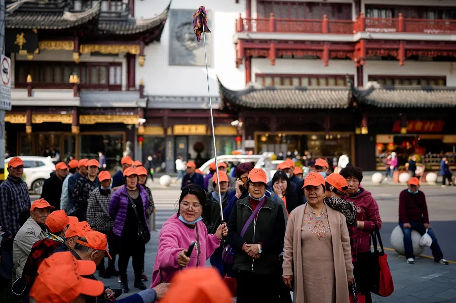 A tour group wearing orange hats visit the Yu Garden in Shanghai, China, 15 March 2023. (Aly Song/Reuters)