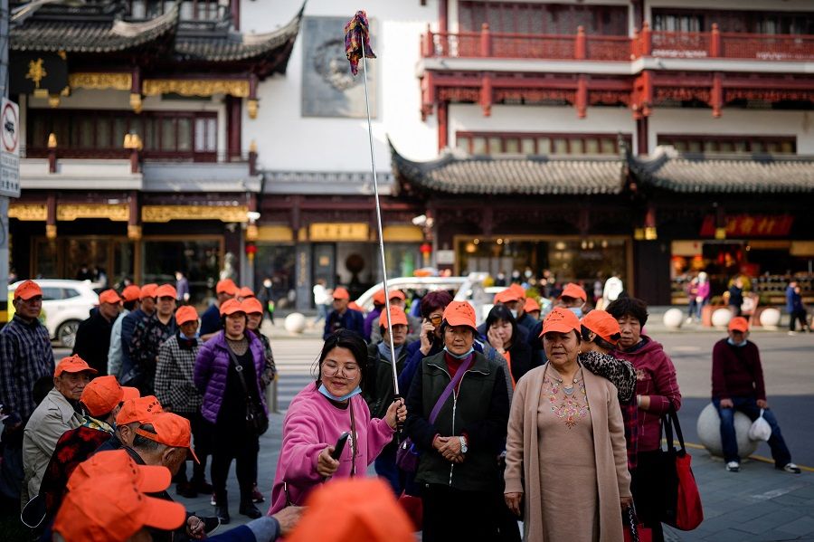 A tour group wearing orange hats visit the Yu Garden in Shanghai, China, 15 March 2023. (Aly Song/Reuters)