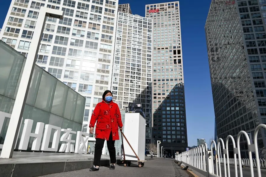 A woman pulls a trolley with goods in the central business district (CBD) of Beijing on 18 January 2021. (Wang Zhao/AFP)