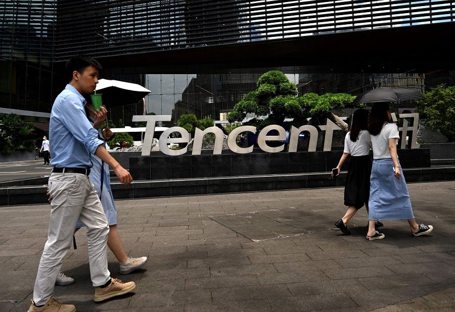 This file photo taken on 26 May 2021 shows people walking past the Tencent headquarters in Shenzhen, Guangdong province, China. (Noel Celis/AFP)