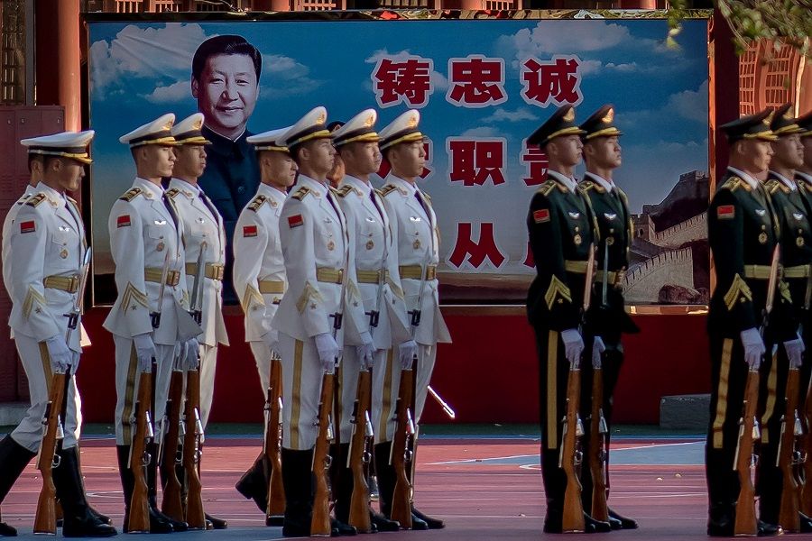 Military personnel stand in formation next to a portrait of Chinese President Xi Jinping (back) outside the Forbidden City in Beijing on 22 October 2020. (Nicolas Asfouri/AFP)