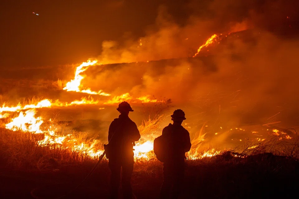 Firefighters battle the Hughes Fire near Castaic Lake, north of Santa Clarita, California, US, on 22 January 2025. (Ringo Chiu/Reuters)
