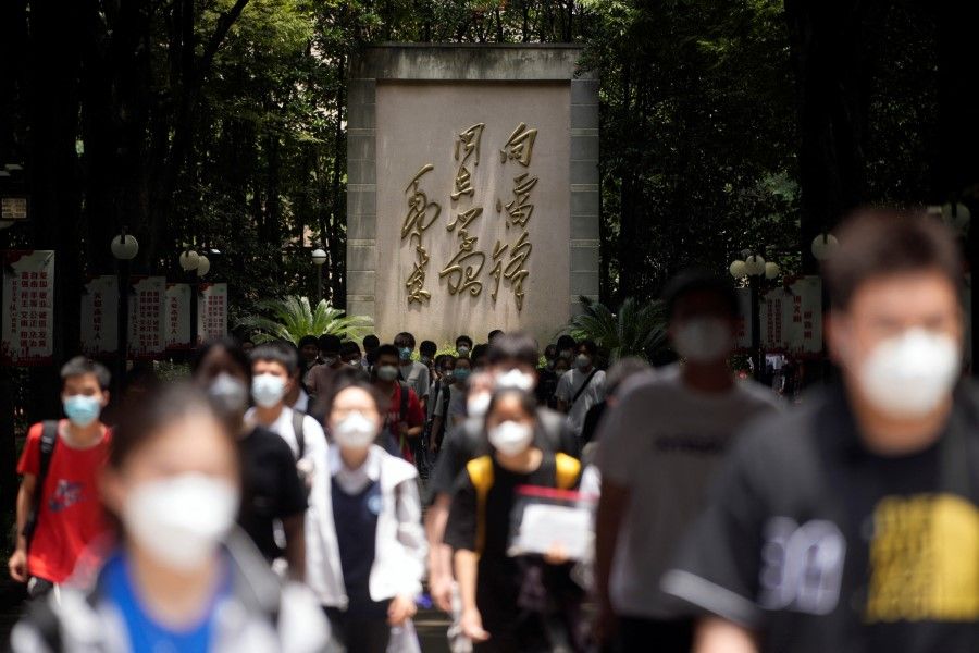 Students wearing face masks walk out of a venue of the annual national "gaokao" university entrance exam in Shanghai, China, 7 July 2022. (Aly Song/Reuters)