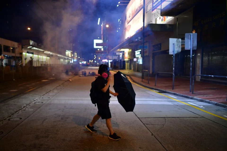 Night falls as a lone protester walks on the street. (Anthony Wallace/AFP)