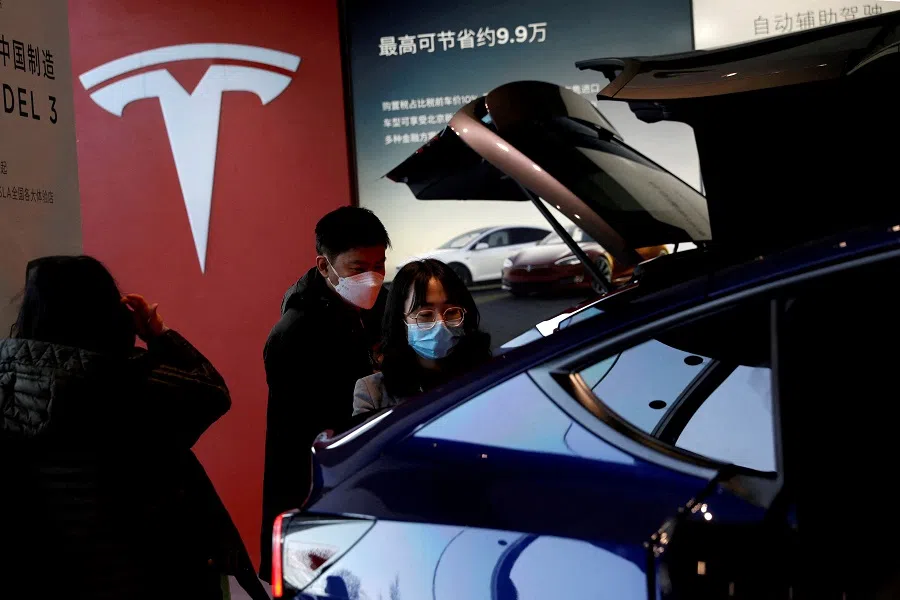 Visitors check a China-made Tesla Model Y sport utility vehicle (SUV) at the electric vehicle maker's showroom in Beijing, China, 5 January 2021. (Tingshu Wang/Reuters)
