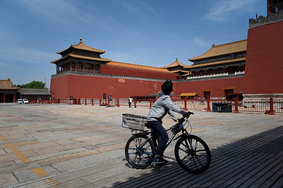 A man riding his bicycle looks at the Forbidden City, closed due to Covid-19 outbreak in Beijing, China, on 17 May 2022. (Wang Zhao/AFP)