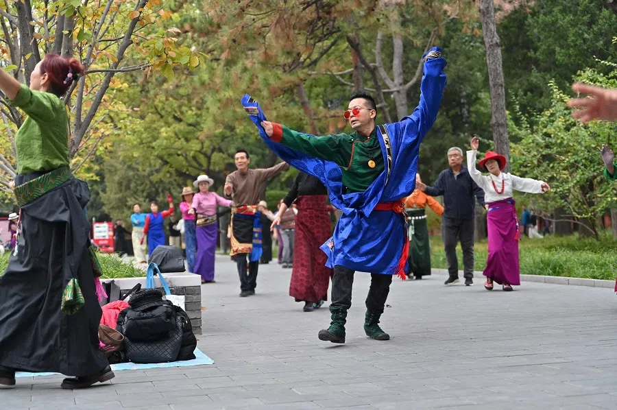 Dance enthusiasts practice Tibetan folk dance at the Ritan park in Beijing on 31 October 2024. (Adek Berry/AFP)