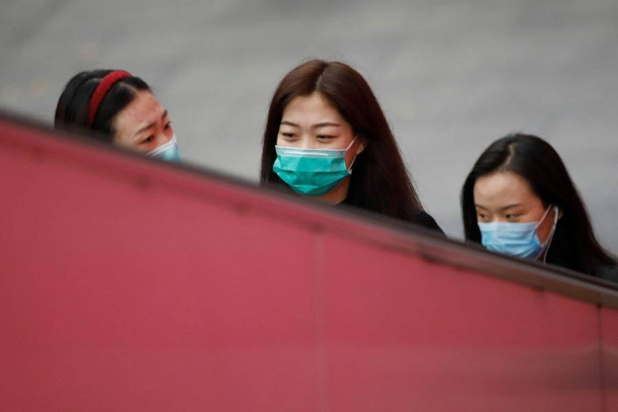 Women wear face masks amid the coronavirus disease (Covid-19) outbreak in Beijing, China, 16 November 2020. (Tingshu Wang/Reuters)