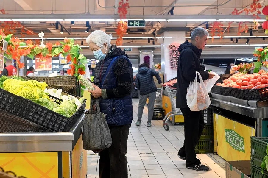 People select vegetables at a supermarket in Beijing, China, on 9 November 2023. (Wang Zhao/AFP)