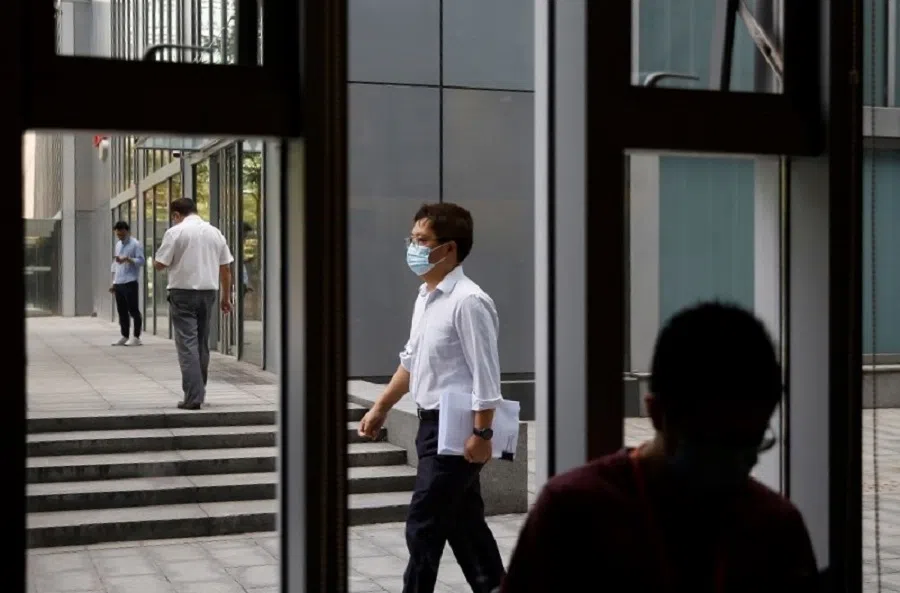 People wearing face masks following the Covid-19 outbreak walk past Starbucks during the morning rush hour at the Financial Street area in Beijing, China, on 16 July 2020. (Tingshu Wang/Reuters)